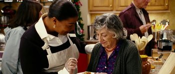 Movie still from “Last Holiday” (2006), directed by Wayne Wang – An older woman is holding a plate of food while an older woman looks on; Close Up shot, Over the shoulder angle