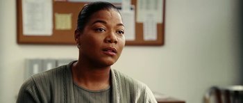 Movie still from “Last Holiday” (2006), directed by Wayne Wang – A person sitting in front of a wall; Close Up shot, Over the shoulder angle