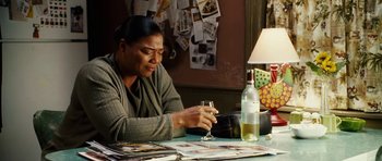 Movie still from “Last Holiday” (2006), directed by Wayne Wang – A woman sitting at a table holding a wine glass; Medium shot, High angle