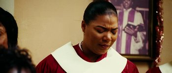 Movie still from “Last Holiday” (2006), directed by Wayne Wang – A woman in a red shirt and a white neck tie; Close Up shot, Low angle