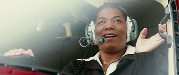 Movie still from “Last Holiday” (2006), directed by Wayne Wang – A woman in a helicopter wearing a headset; Close Up shot, Low angle