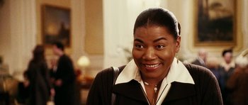 Movie still from “Last Holiday” (2006), directed by Wayne Wang – A woman smiling for the camera while wearing a black jacket; Close Up shot, Over the shoulder angle