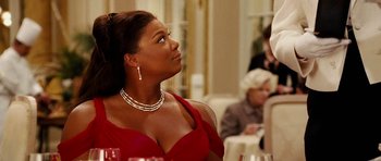 Movie still from “Last Holiday” (2006), directed by Wayne Wang – A woman in a red dress sitting at a table; Close Up shot, Over the shoulder angle