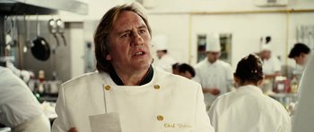 Movie still from “Last Holiday” (2006), directed by Wayne Wang – A man wearing a chef's outfit in a kitchen; Close Up shot, Low angle