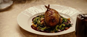 Movie still from “Last Holiday” (2006), directed by Wayne Wang – A white plate topped with meat covered in sauce and vegetables; Extreme Close Up shot, High angle