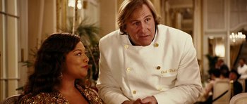 Movie still from “Last Holiday” (2006), directed by Wayne Wang – A man and a woman sitting next to each other; Medium shot, Over the shoulder angle