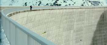 Movie still from “Last Holiday” (2006), directed by Wayne Wang – A man riding a snowboard down the side of a snow covered slope; Extreme Wide shot, Overhead angle