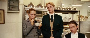 Movie still from “Last Holiday” (2006), directed by Wayne Wang – A woman and a man standing next to each other in a kitchen; Medium shot, Low angle