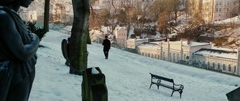 Movie still from “Last Holiday” (2006), directed by Wayne Wang – A person walking in the snow next to a park bench; Extreme Wide shot, High angle
