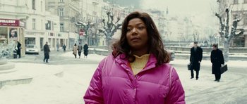 Movie still from “Last Holiday” (2006), directed by Wayne Wang – A woman in a pink jacket standing on a sidewalk; Medium shot, Over the shoulder angle