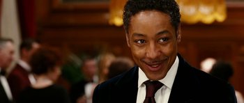 Movie still from “Last Holiday” (2006), directed by Wayne Wang – A person wearing a suit and tie; Close Up shot, Over the shoulder angle