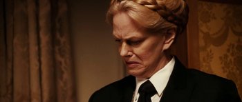 Movie still from “Last Holiday” (2006), directed by Wayne Wang – An older woman in a black suit and a black tie; Close Up shot, Over the shoulder angle