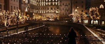 Movie still from “Last Holiday” (2006), directed by Wayne Wang – A woman standing on a bridge in front of a building at night; Extreme Wide shot, High angle