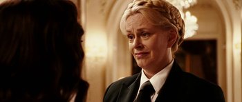 Movie still from “Last Holiday” (2006), directed by Wayne Wang – A woman with blonde hair wearing a black suit and white tie; Close Up shot, Over the shoulder angle