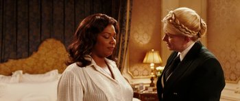 Movie still from “Last Holiday” (2006), directed by Wayne Wang – Two women standing next to each other in a room; Medium shot, Over the shoulder angle