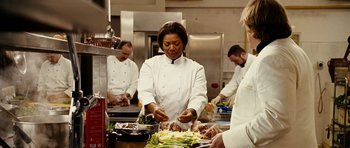 Movie still from “Last Holiday” (2006), directed by Wayne Wang – A group of people in a kitchen preparing food; Medium shot, Over the shoulder angle