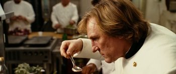 Movie still from “Last Holiday” (2006), directed by Wayne Wang – A man holding a spoon in a kitchen; Close Up shot, Low angle