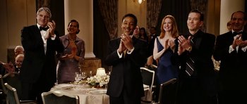 Movie still from “Last Holiday” (2006), directed by Wayne Wang – A group of people standing in a room clapping; Medium shot, Over the shoulder angle