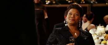 Movie still from “Last Holiday” (2006), directed by Wayne Wang – A woman sitting at a table holding a wine glass; Close Up shot, Over the shoulder angle