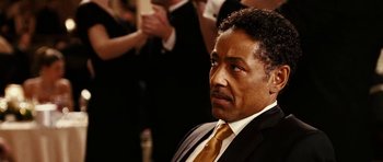 Movie still from “Last Holiday” (2006), directed by Wayne Wang – A man in a black suit and a yellow tie; Close Up shot, Over the shoulder angle