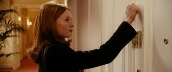 Movie still from “Last Holiday” (2006), directed by Wayne Wang – A woman in a black jacket is holding her hand up to a window; Close Up shot, Over the shoulder angle