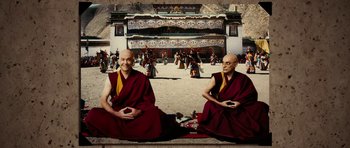 Movie still from “Last Holiday” (2006), directed by Wayne Wang – Two monks sitting on the ground in front of an audience; Wide shot, High angle