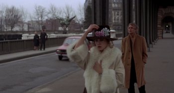 Movie still from “Last Tango in Paris” (1972), directed by Bernardo Bertolucci – A woman wearing a fur coat and a hat on the side of the street; Medium shot, Over the shoulder angle