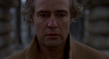 Movie still from “Last Tango in Paris” (1972), directed by Bernardo Bertolucci – A person wearing a brown jacket; Close Up shot, Low angle