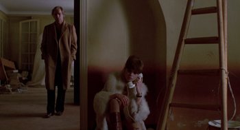 Movie still from “Last Tango in Paris” (1972), directed by Bernardo Bertolucci – A woman sitting on a chair while holding a phone to her ear; Wide shot, Low angle