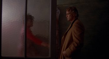 Movie still from “Last Tango in Paris” (1972), directed by Bernardo Bertolucci – A man standing in front of a window looking at a woman; Medium shot, Over the shoulder angle