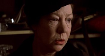 Movie still from “Last Tango in Paris” (1972), directed by Bernardo Bertolucci – An older woman wearing a black hat looking sad; Close Up shot, Low angle