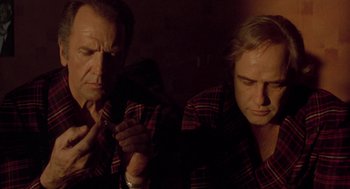 Movie still from “Last Tango in Paris” (1972), directed by Bernardo Bertolucci – A couple of men sitting next to each other; Close Up shot, Low angle
