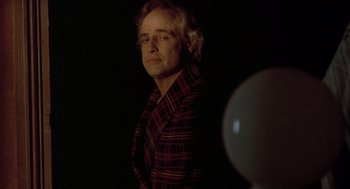 Movie still from “Last Tango in Paris” (1972), directed by Bernardo Bertolucci – A man standing in the dark with his head turned to the side; Medium shot, Low angle