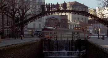 Movie still from “Last Tango in Paris” (1972), directed by Bernardo Bertolucci – A group of people standing on top of a wooden bridge; Extreme Wide shot, High angle