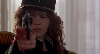 Movie still from “Last Tango in Paris” (1972), directed by Bernardo Bertolucci – A woman with curly hair holding a gun in her hand; Close Up shot, Low angle