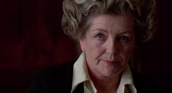 Movie still from “Last Tango in Paris” (1972), directed by Bernardo Bertolucci – An older woman wearing a black jacket and a white shirt; Close Up shot, Over the shoulder angle