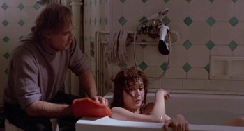 Movie still from “Last Tango in Paris” (1972), directed by Bernardo Bertolucci – A woman sitting in a bath tub while a man is cleaning her hair; Medium shot, Over the shoulder angle