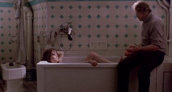 Movie still from “Last Tango in Paris” (1972), directed by Bernardo Bertolucci – A woman laying in a bath tub next to a man; Wide shot, High angle