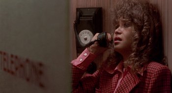 Movie still from “Last Tango in Paris” (1972), directed by Bernardo Bertolucci – A woman talking on a phone in front of a wall mounted phone; Close Up shot, High angle