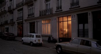 Movie still from “Last Tango in Paris” (1972), directed by Bernardo Bertolucci – A car parked on the side of the road near a building; Extreme Wide shot, High angle