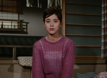 Movie still from “Late Autumn” (1960), directed by Yasujirô Ozu – A woman in a purple sweater sitting in a room; Medium shot, High angle