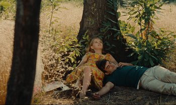 Movie still from “Happiness” (1965), directed by Agnès Varda – A man and a woman laying on the ground under a tree; Medium shot, Low angle