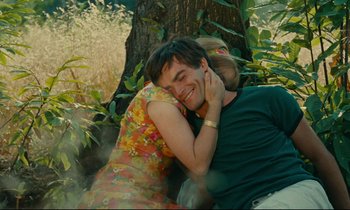 Movie still from “Happiness” (1965), directed by Agnès Varda – A man and a woman sitting next to a tree; Medium shot, Over the shoulder angle