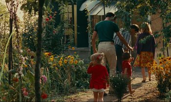 Movie still from “Happiness” (1965), directed by Agnès Varda – A man and two children are walking in a garden; Wide shot, High angle
