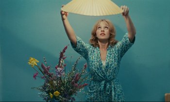 Movie still from “Happiness” (1965), directed by Agnès Varda – A woman holding an umbrella above her head; Medium shot, Low angle