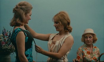 Movie still from “Happiness” (1965), directed by Agnès Varda – A woman is helping another woman with her hair; Medium shot, Low angle