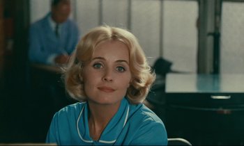 Movie still from “Happiness” (1965), directed by Agnès Varda – A woman with blonde hair and blue eyes; Close Up shot, Over the shoulder angle