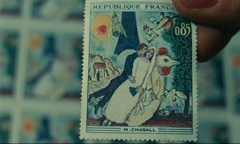 Movie still from “Happiness” (1965), directed by Agnès Varda – A stamp with a picture of a man and a woman; Extreme Close Up shot, High angle