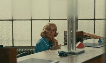 Movie still from “Happiness” (1965), directed by Agnès Varda – A woman sitting at a table in front of a window; Medium shot, Over the shoulder angle