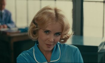 Movie still from “Happiness” (1965), directed by Agnès Varda – A woman with blonde hair wearing a blue shirt; Close Up shot, Over the shoulder angle